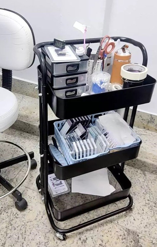 carrinho multiuso com 3 prateleiras preto com produtos de beleza em um salão magazine decor