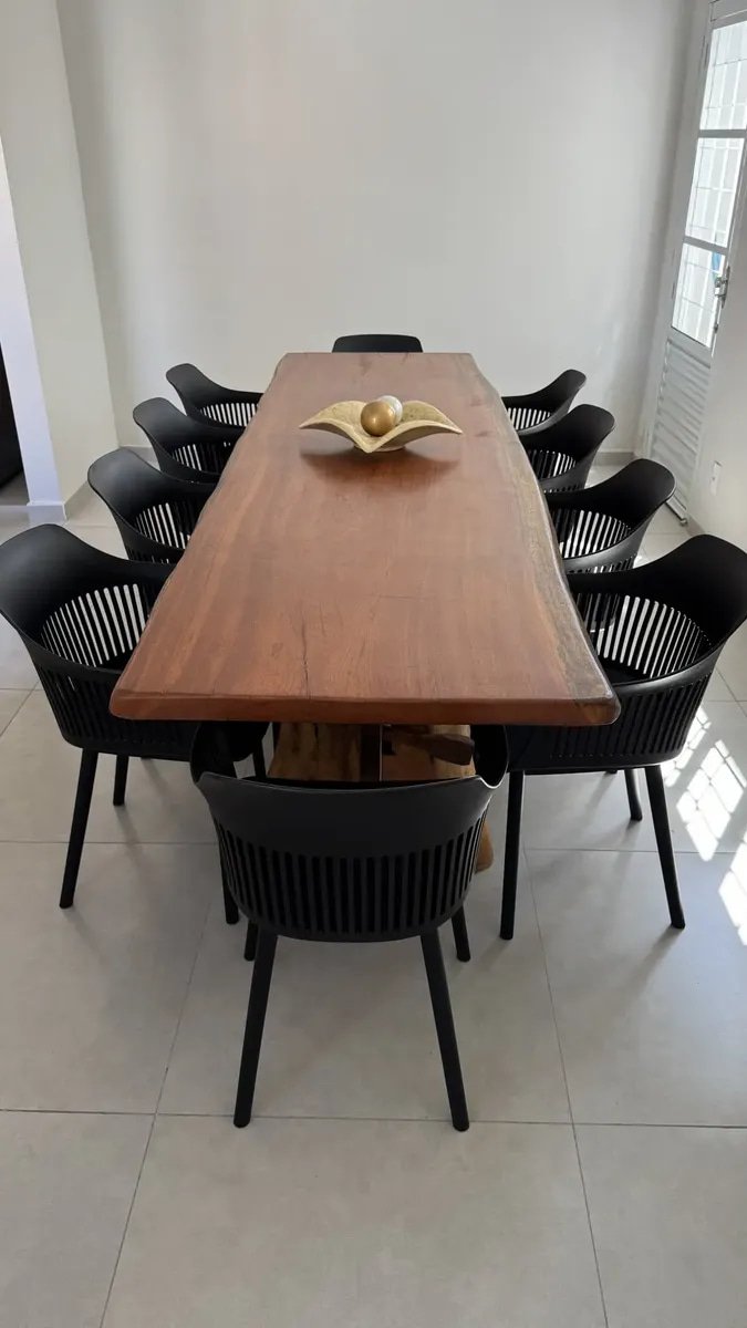 Mesa de jantar retangular em madeira maciça com oito cadeiras Marcela pretas com braços em sala de projeto residencial